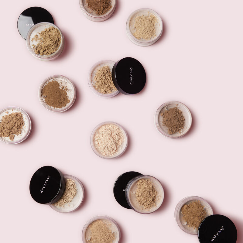 Open jars of Mary Kay Silky Setting Powder against pink background. image number null