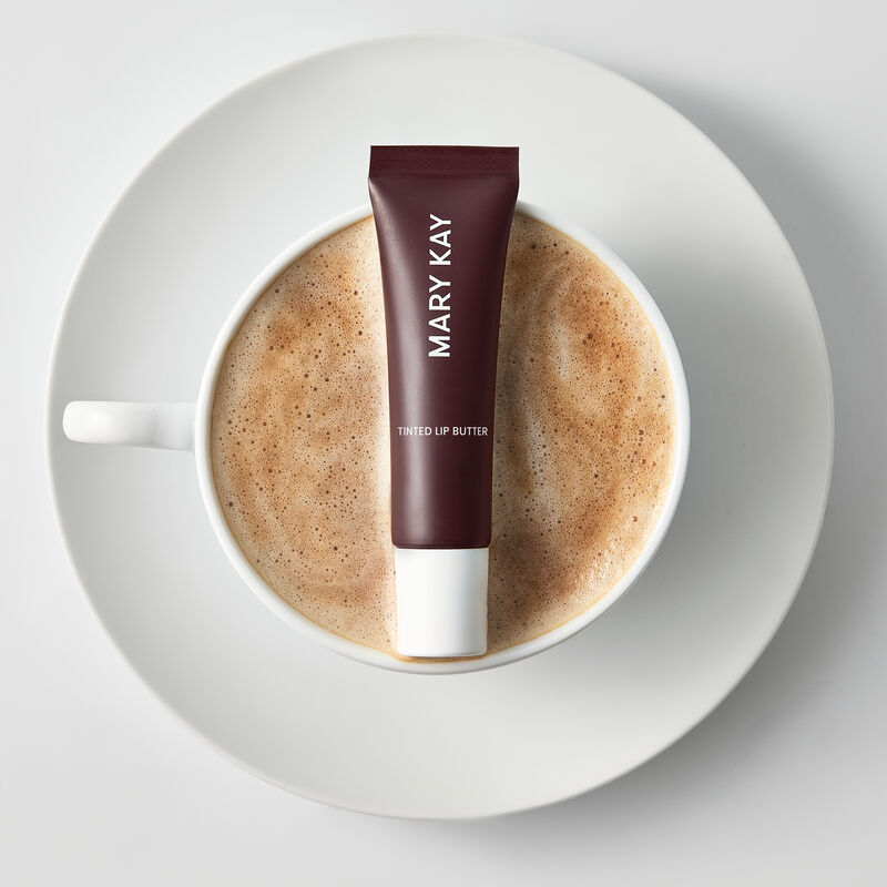 Tinted Lip Butter in Dulce Latte styled atop a foamy latte