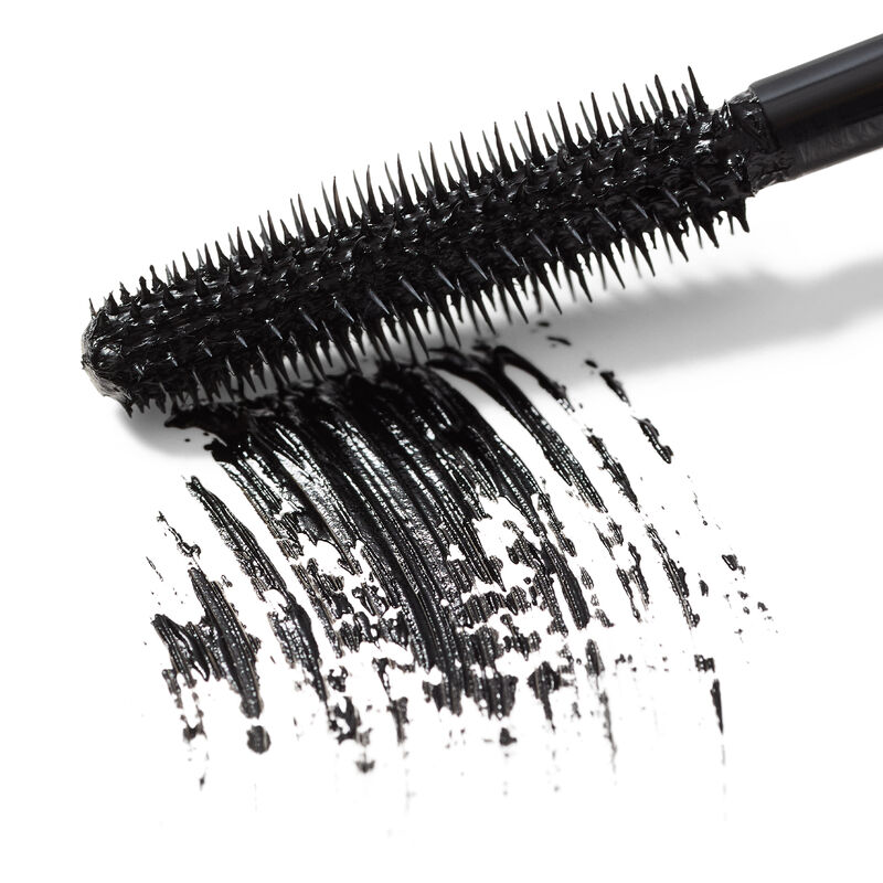 Close-up hero image of Mary Kay Great Heights Waterproof Mascara wand swiping a black product rub against a white surface&nbsp; image number null