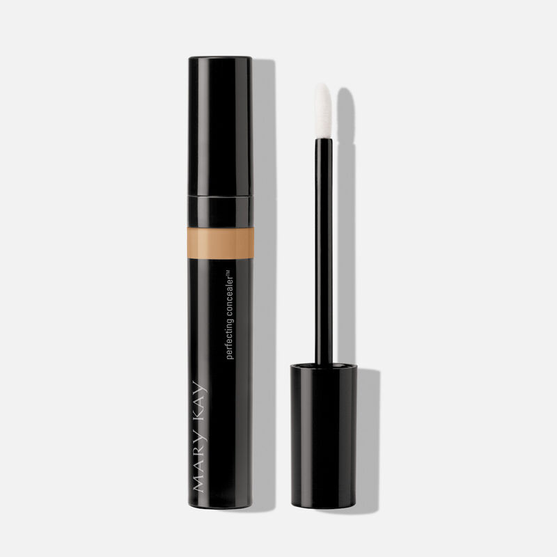 Tube of Mary Kay Perfecting Concealer in shade Light Bronze with cap on next to accompanying applicator. image number null
