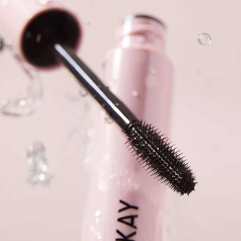 Close-up hero image of Mary Kay Great Heights Waterproof Mascara with tube open and wand positioned in front of it styled with water droplets image number null