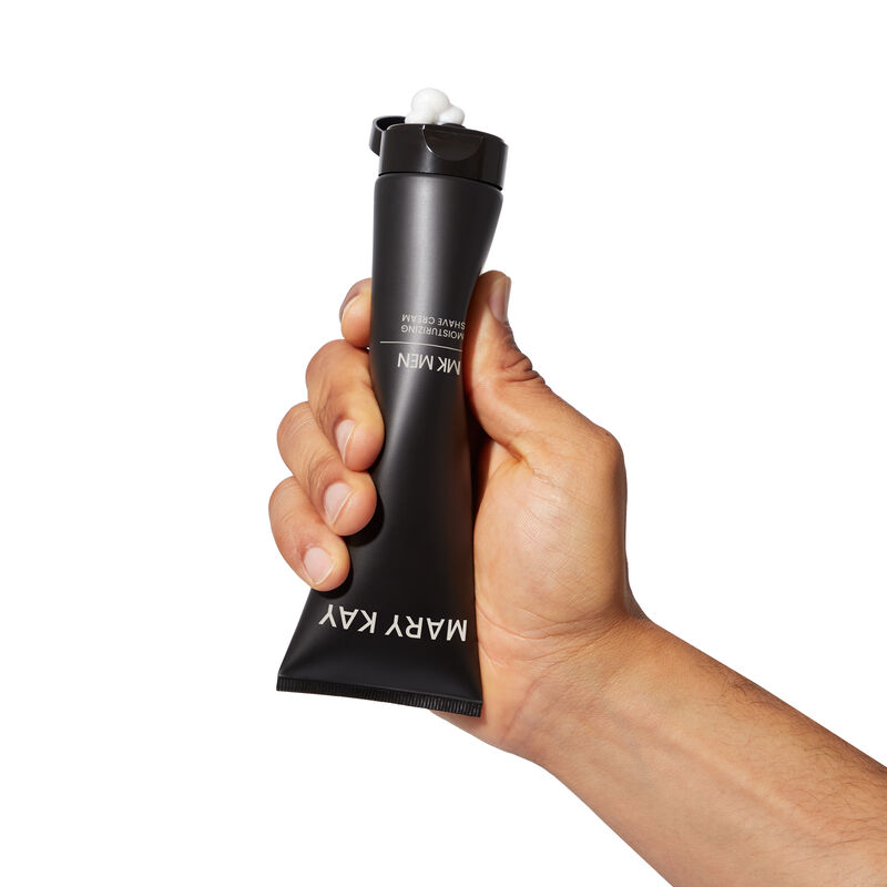 MKMen Moisturizing Shave Cream being squeezed by a man&rsquo;s hand while held upside down
