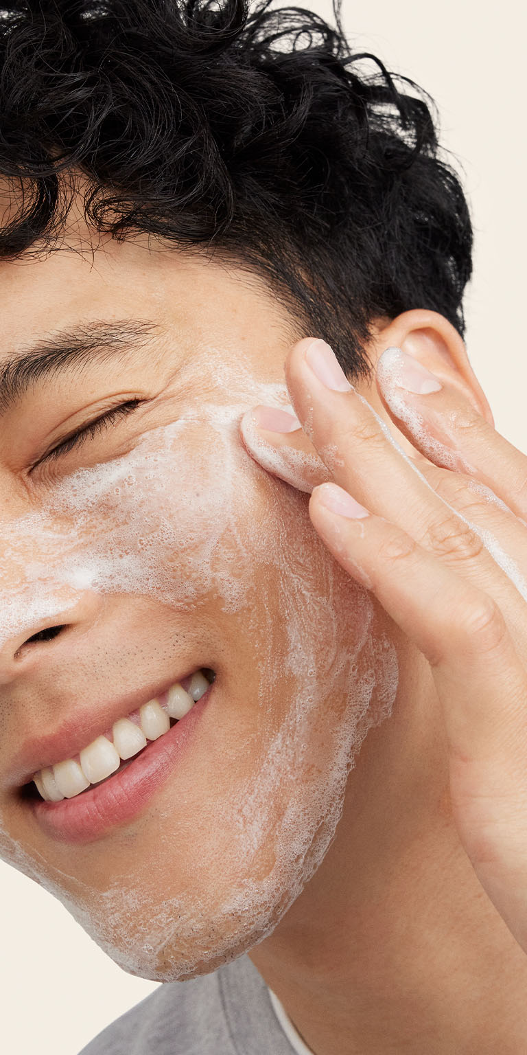Modelo masculino aplicando el Gel Limpiador Facial MKMen&reg; en el lateral del rostro