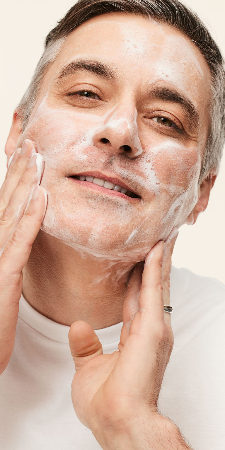 Modelo masculino aplicando el Gel Limpiador Facial MKMen&reg; en el rostro