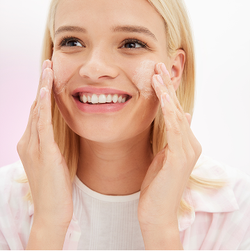 Modelo rubia aplicando el Limpiador Matificante Mary Kay&reg; en el rostro